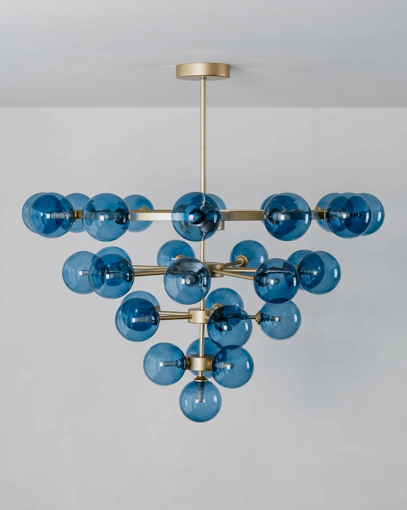 Celestine tiered bubble chandelier detail view showcasing brass-tone metal frame and precision-arranged blue glass globes