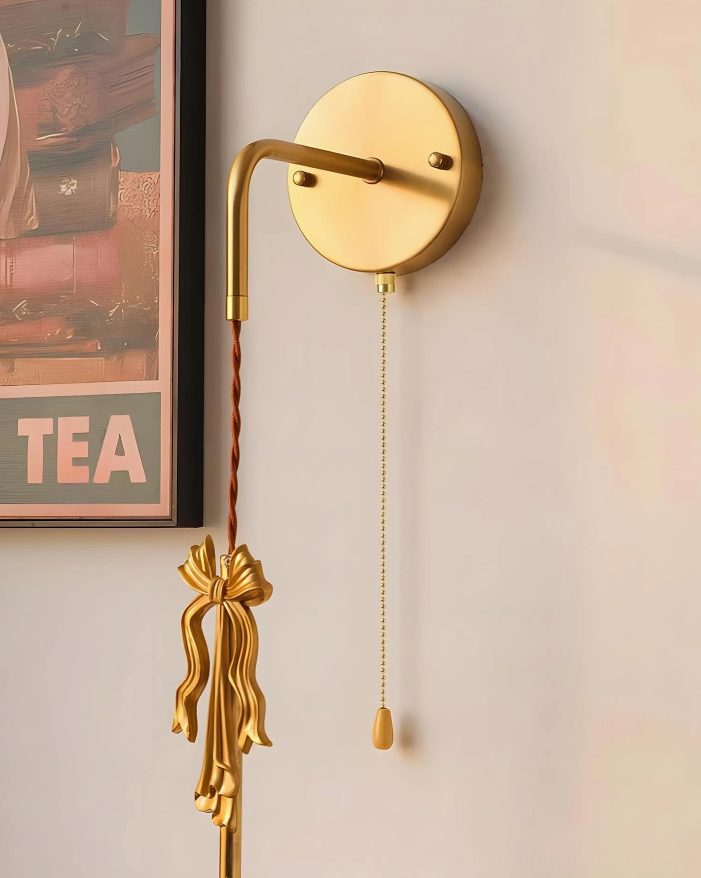 Close-up detail of Celestine wall sconce brass gold bow ornament and wall mount hardware