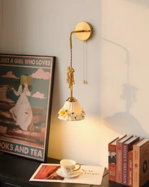 Celestine wall sconce with flower-patterned ceramic shade installed above side table in vintage home interior setting