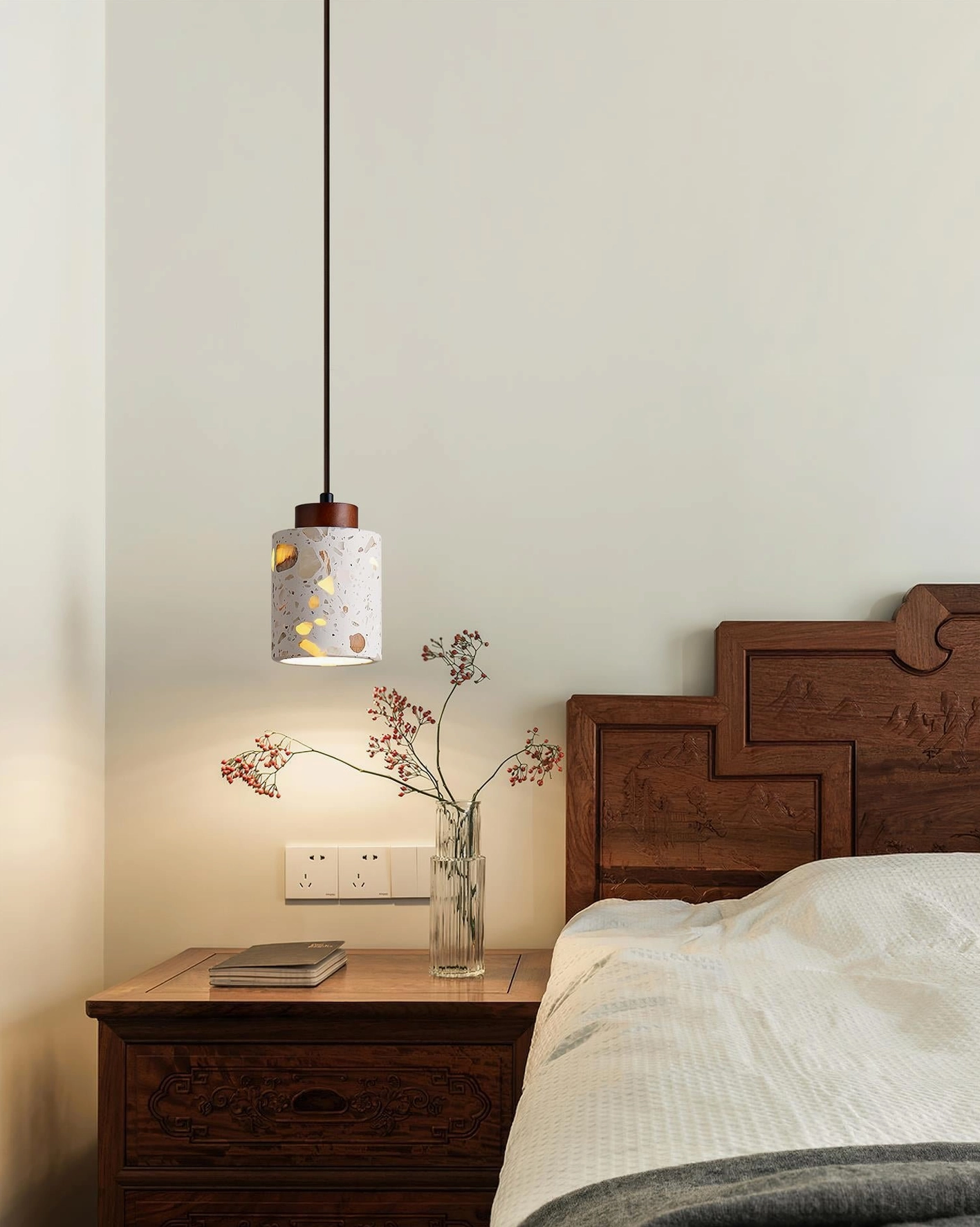 Cemento terrazzo pendant light fixture eye-level view above wooden bed frame bedroom