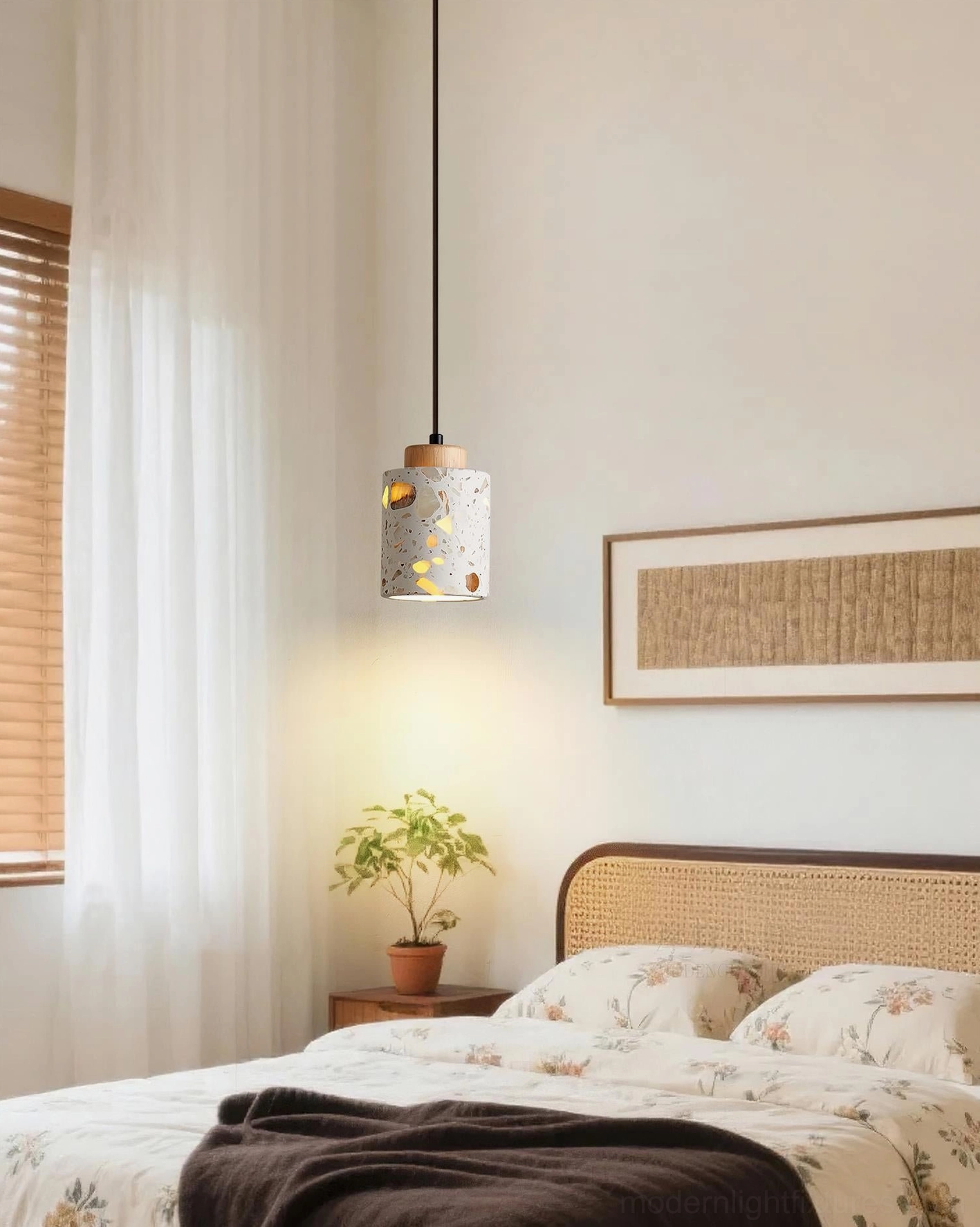 Cylindrical terrazzo pendant lamp hanging over upholstered bed in residential bedroom