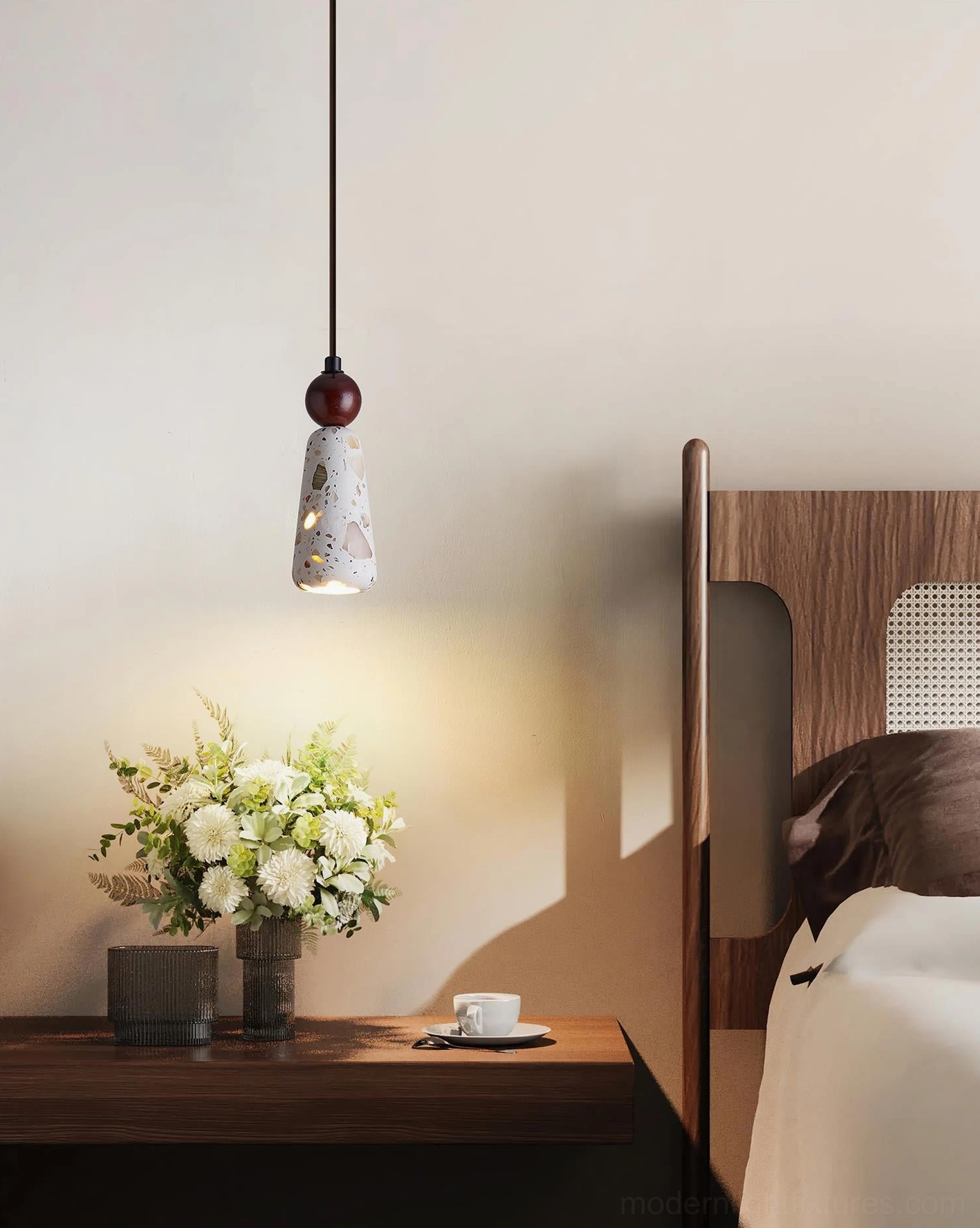 Tapered cemento terrazzo pendant light installed above bedroom nightstand side view
