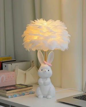 Lit pastel bunny lamp with warm white feather shade on home office desk - three-quarter angle