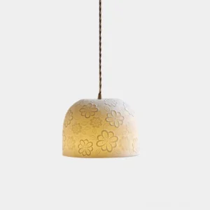 Handcrafted ceramic floral pendant light with embossed botanical pattern, matte beige finish, front view on studio white backdrop