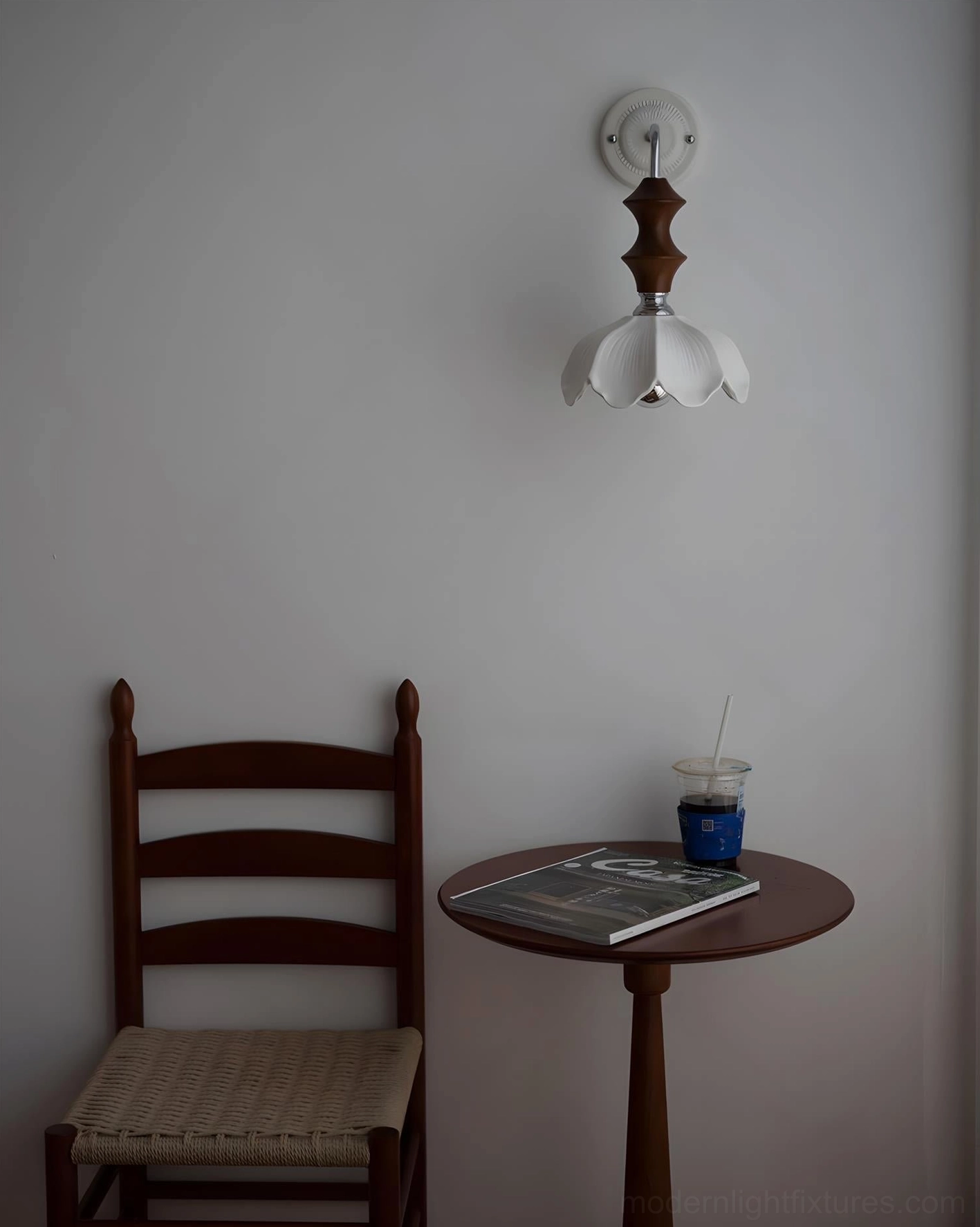 Floral ceramic wall sconce mounted on dark wall in cafe-style seating area with wooden furniture