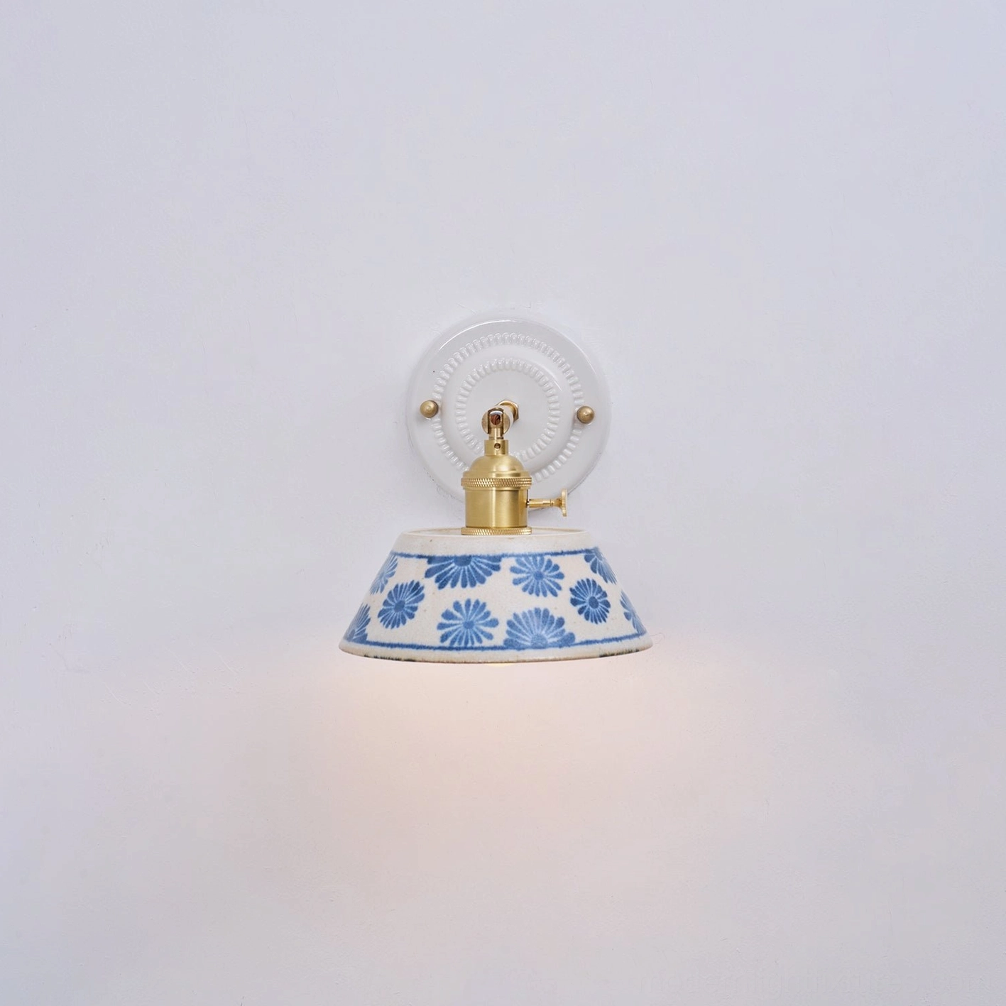 Ceramic wall lamp detail showing glaze finish and indigo floral ceramic shade motifs
