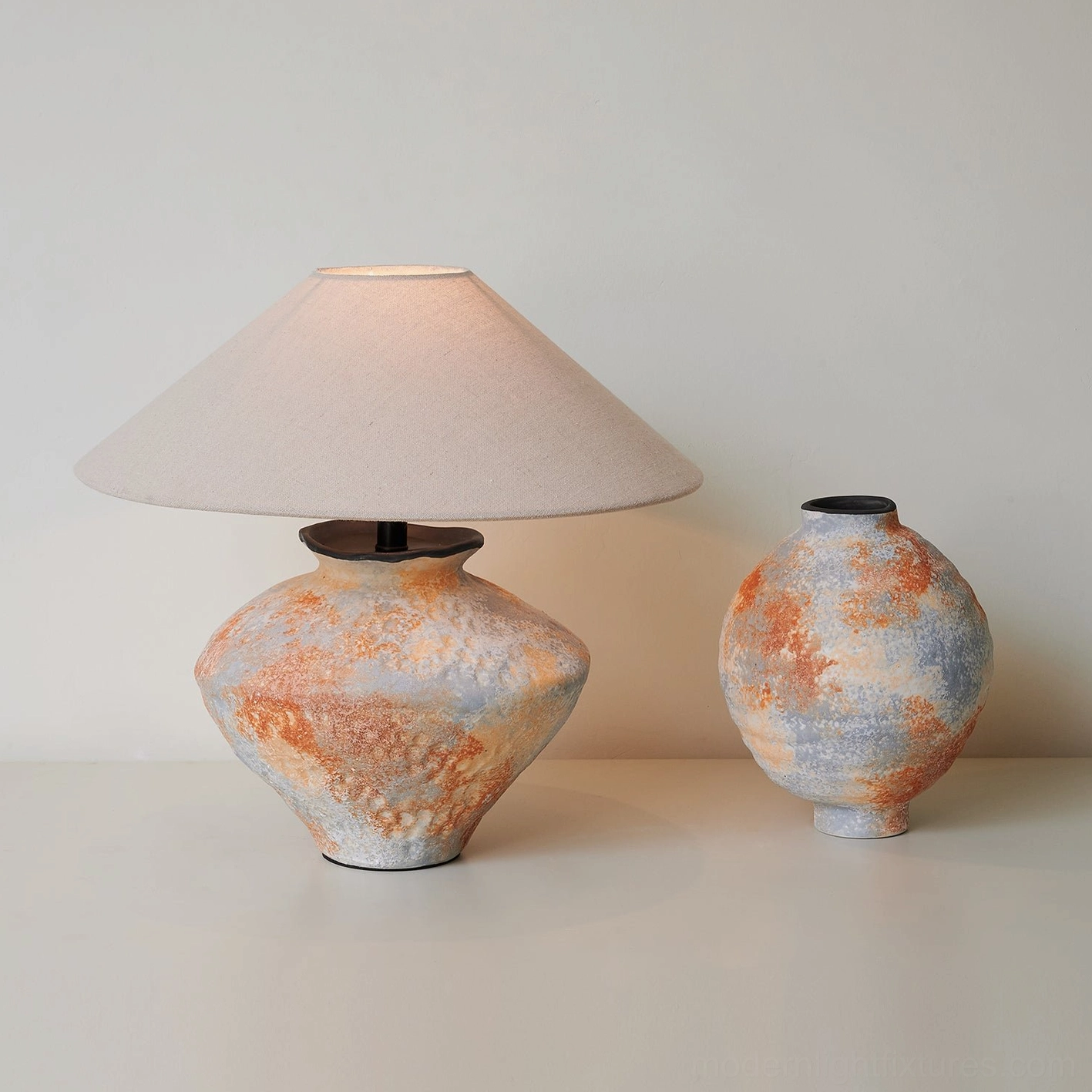 Ceramic table lamp paired with matching decorative ceramic vase showing coordinated earth-tone glaze texture