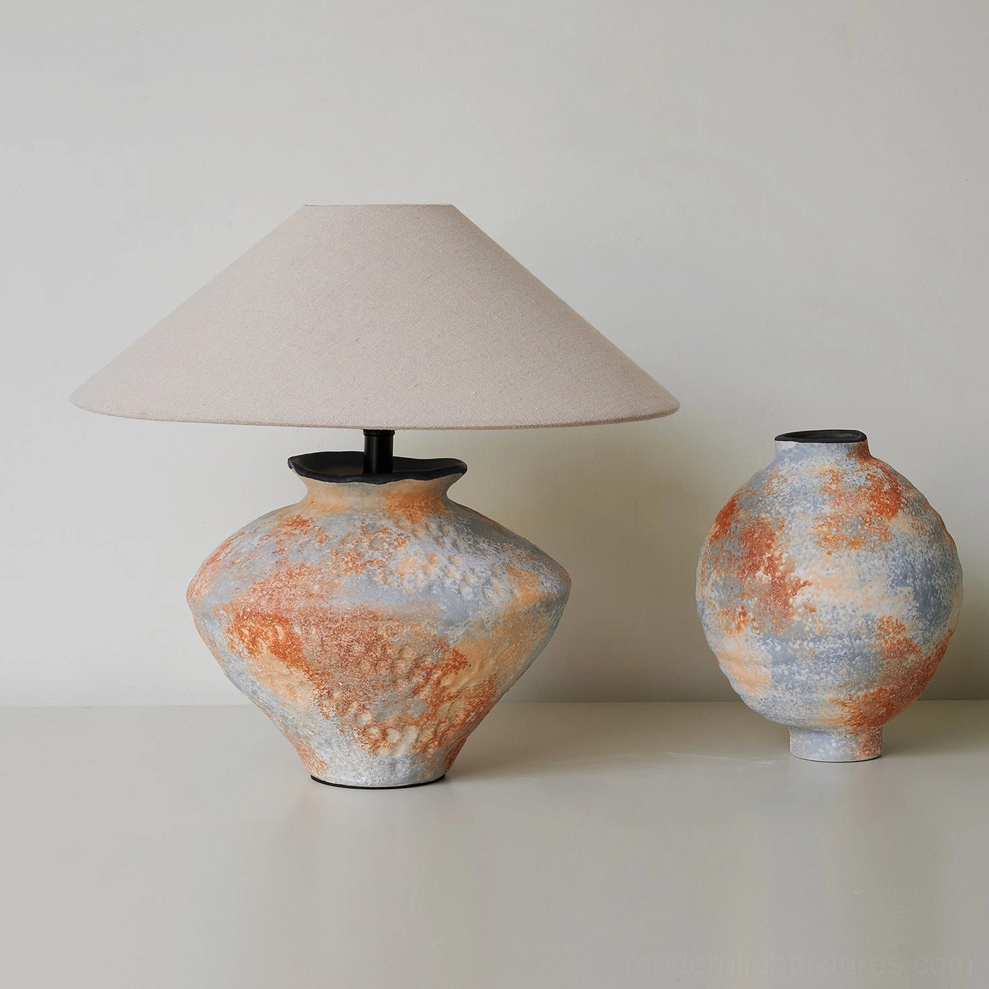 Ceramic table lamp with coordinating ceramic vase front view light tabletop background