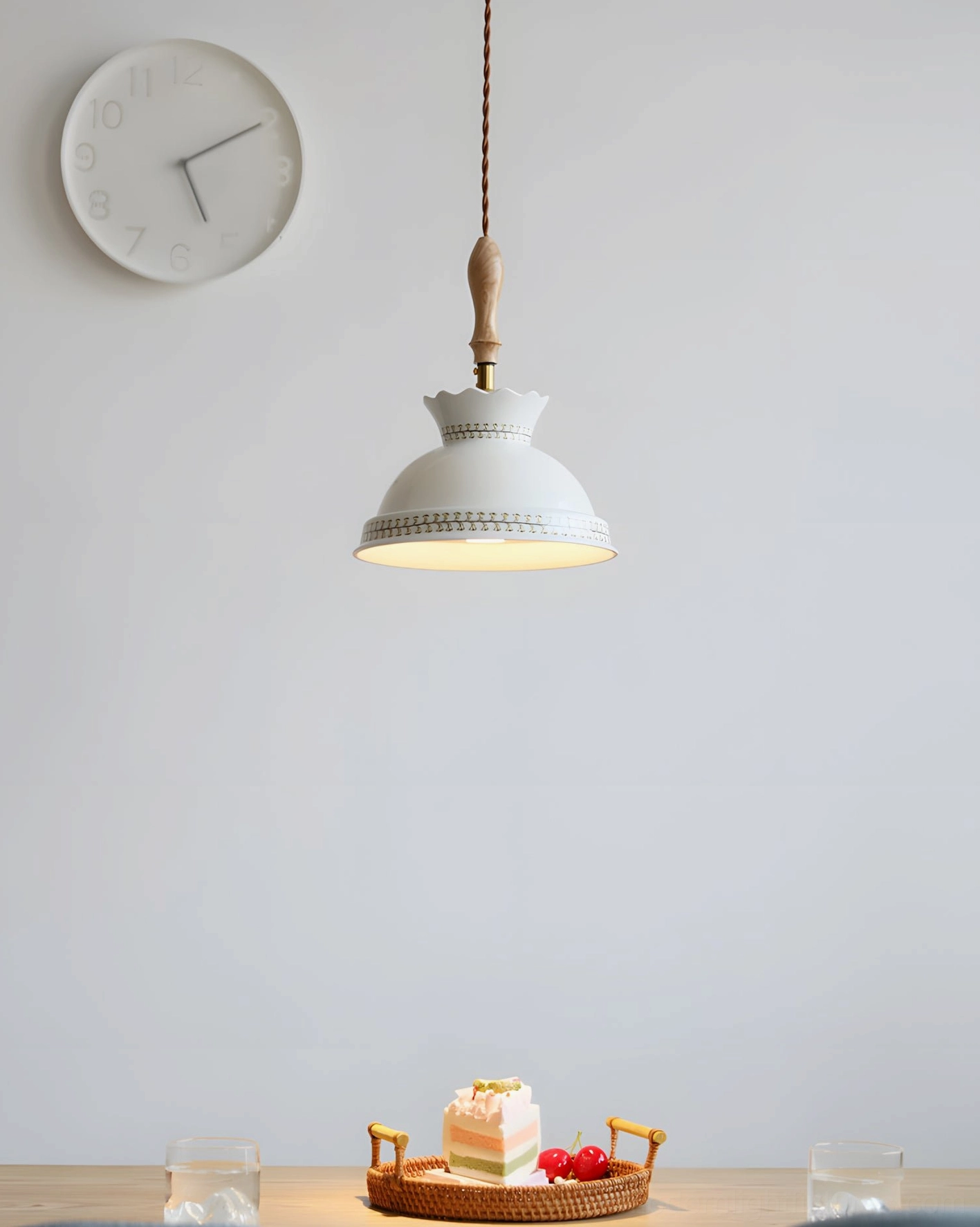Ceramic pendant light showing brass and turned wood fixture details and twisted cord
