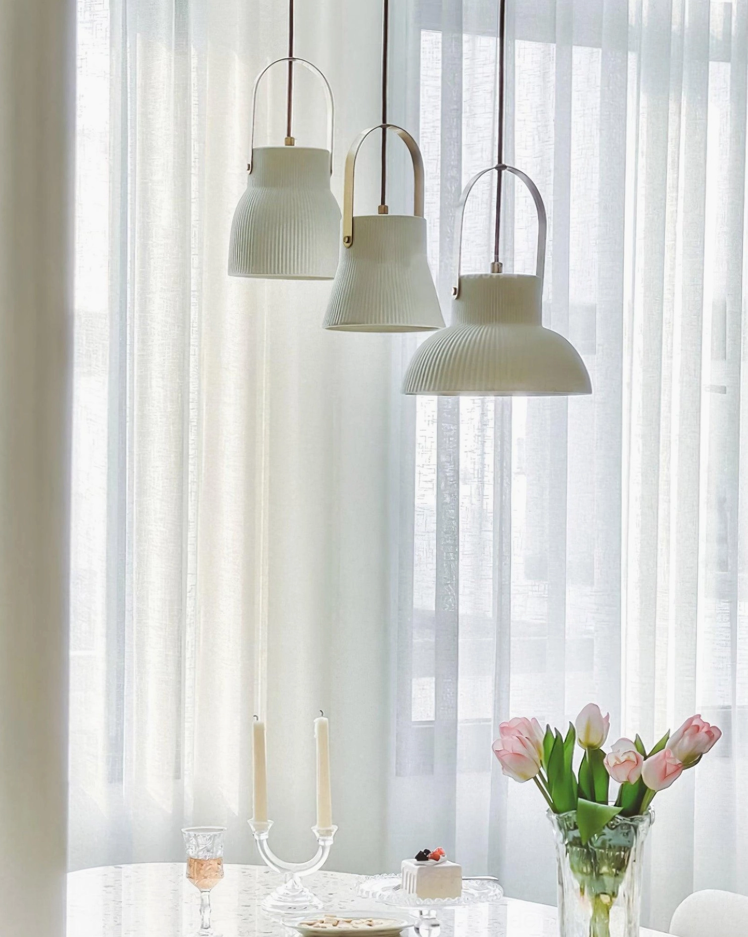 Ceramic pendant fixture installation showing light diffusion through ribbed shade