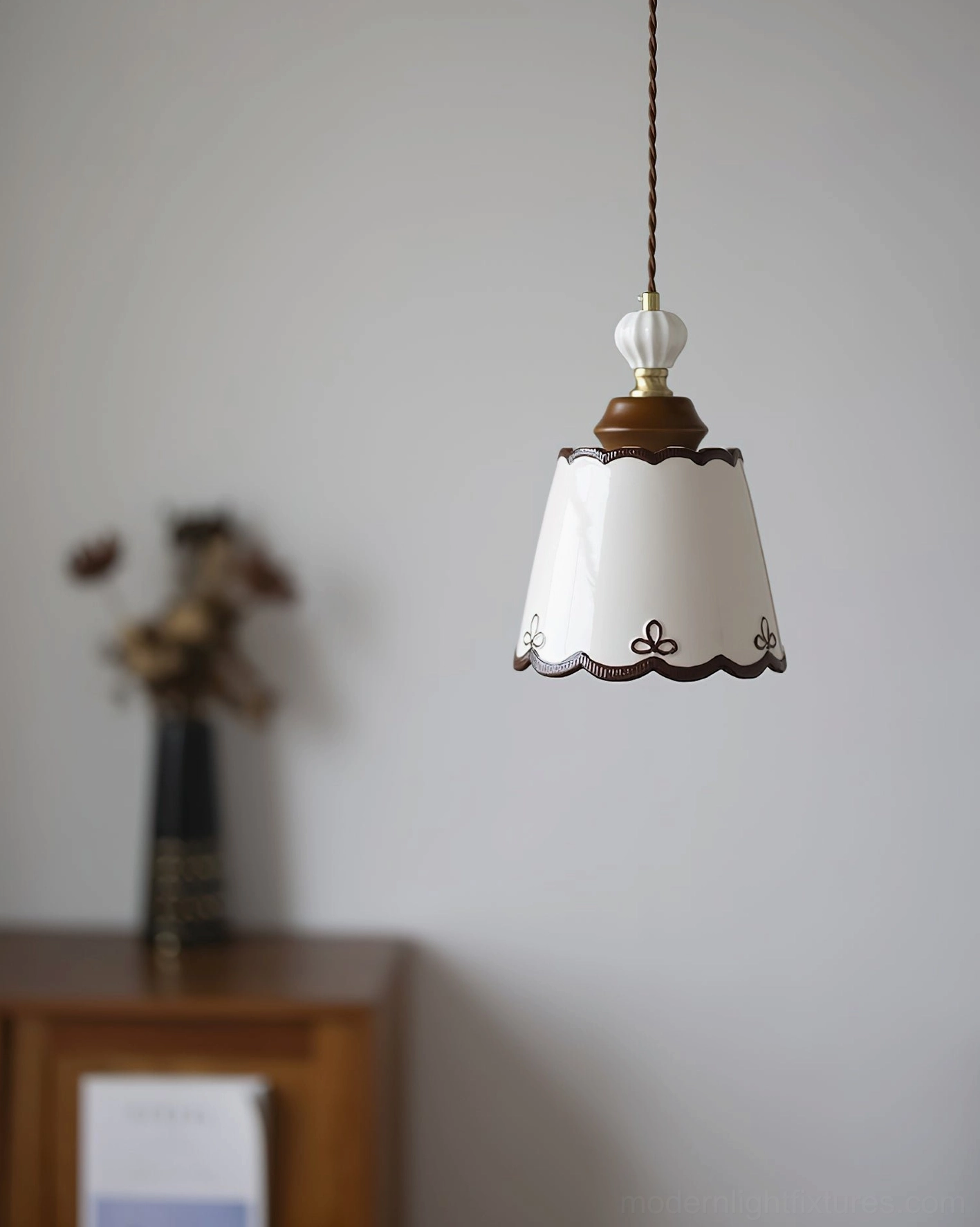 Vintage ceramic pendant light installed beside wooden bedside table with dried flower decor in boho bedroom