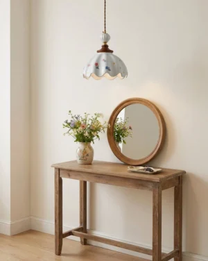 Cottagecore ceramic pendant light hanging above wooden bedroom vanity with round mirror and warm ambient glow, cozy bedroom aesthetic
