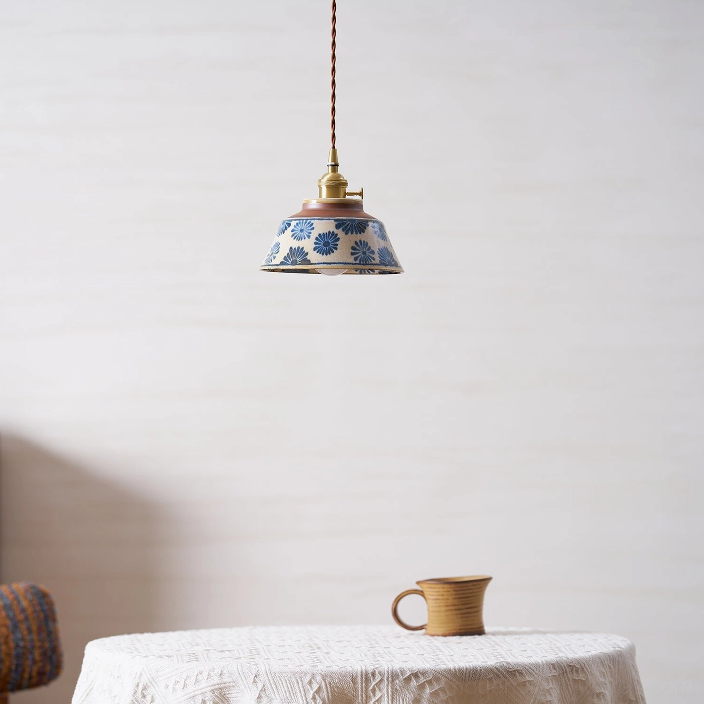 Ceramic pendant light in monochromatic styling with brass fixtures and twisted cord assembly