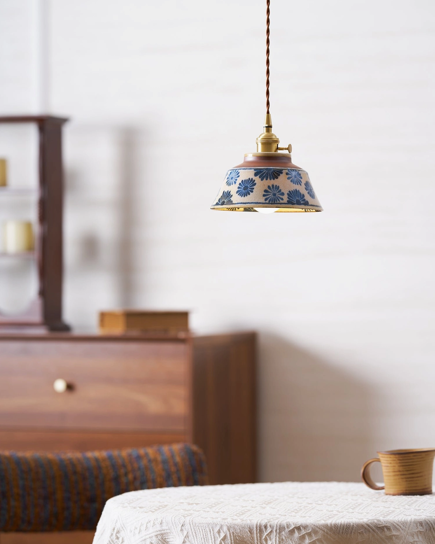 Dimmed ceramic pendant light creating warm ambient mood for evening dining atmosphere