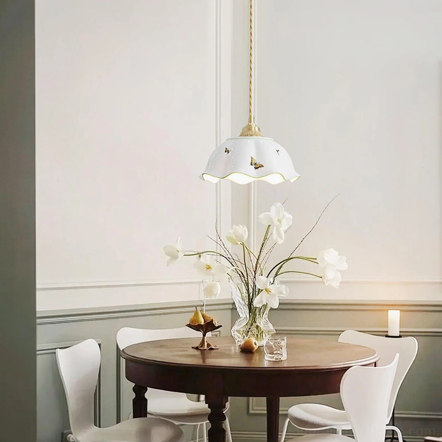 Ceramic butterfly pendant lamp above wooden dining table in warm pastoral dining room