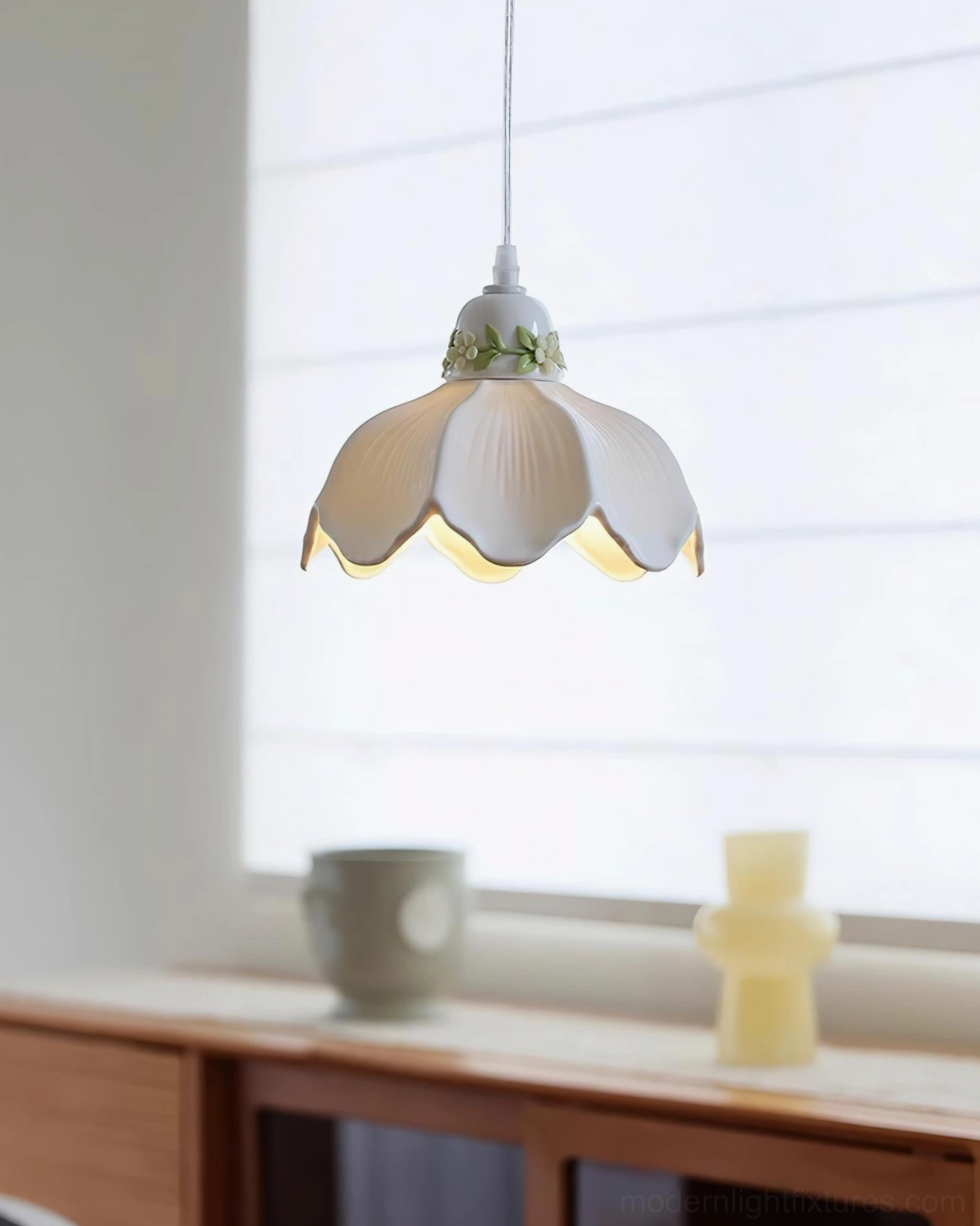 Ceramic pendant light with botanical hand-painted design above wooden console table entryway, warm ambient illumination