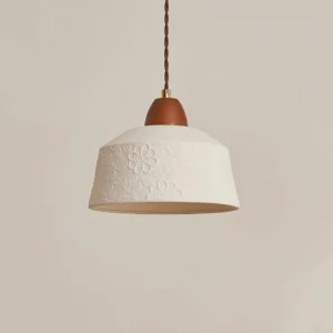Three-quarter overhead view of ceramic embossed pendant light highlighting dimensional floral texture and curved shade profile