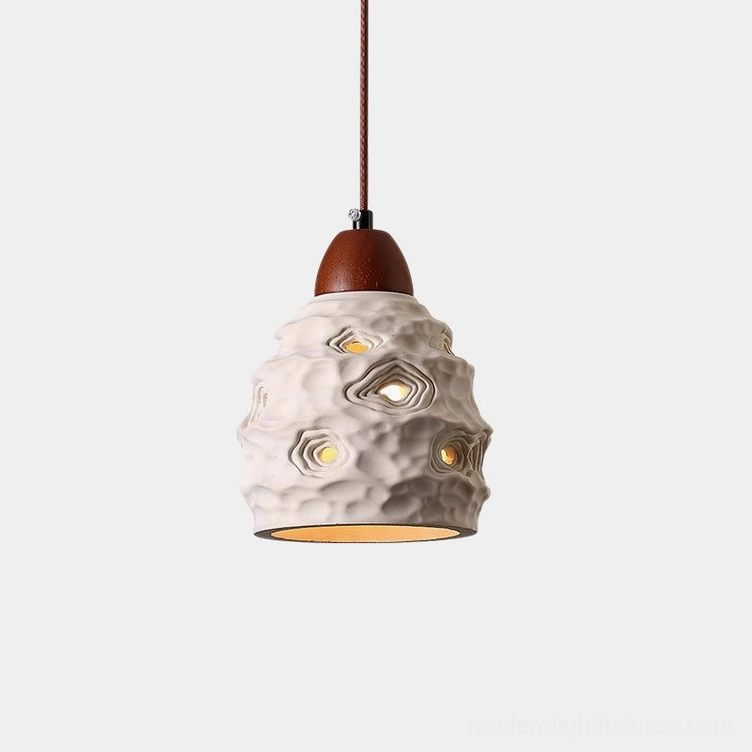 Organic ceramic pendant light with sculptural texture and perforated shade in off-white with walnut wood accent - frontal studio view