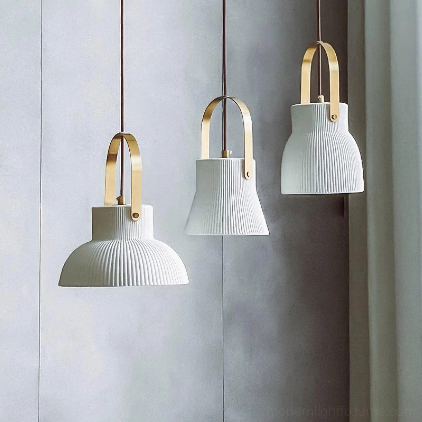 Three mixed size ceramic pendant lights with ribbed shades installed in minimalist space