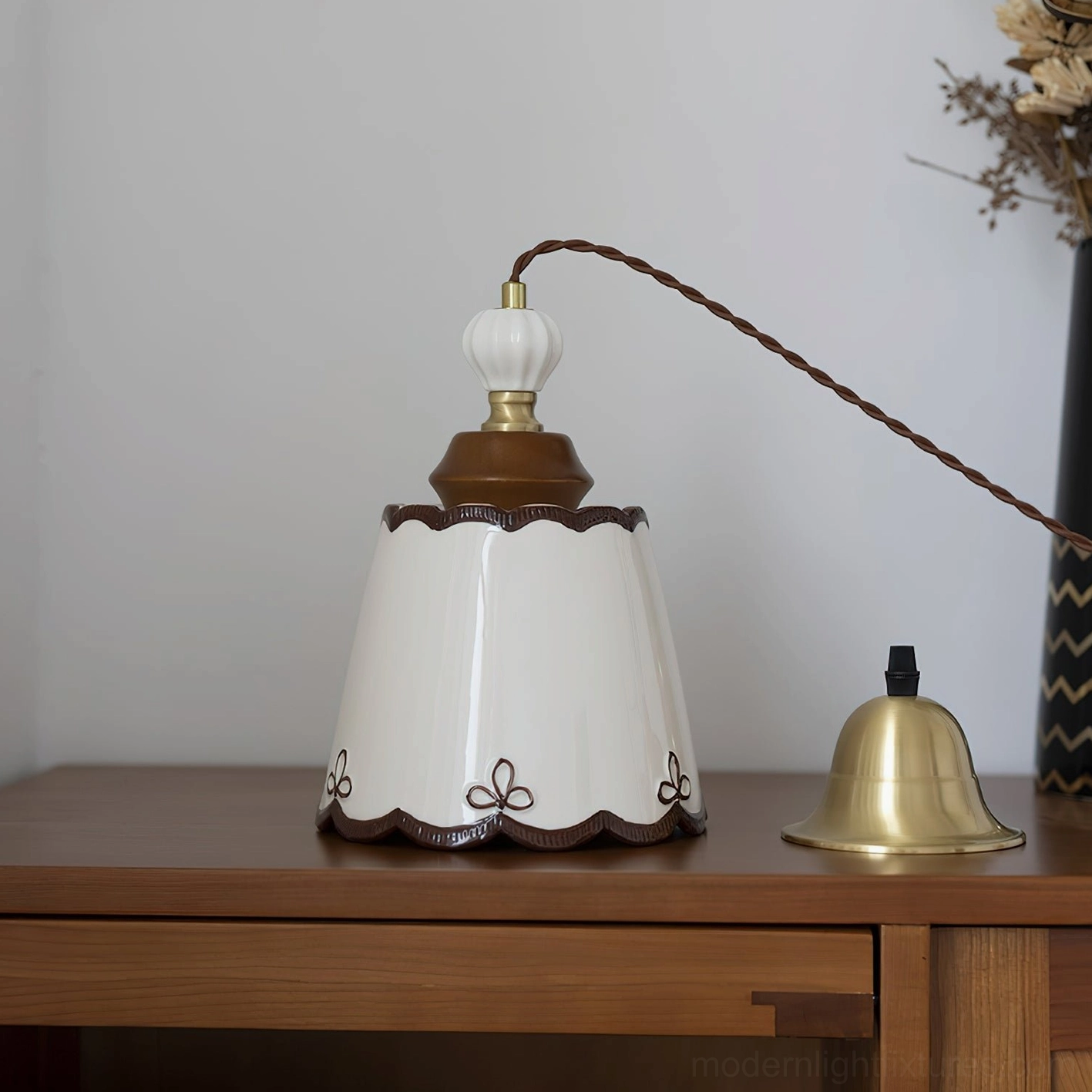 Ceramic pendant lamp components displayed on wooden desk showing shade and brass mounting hardware