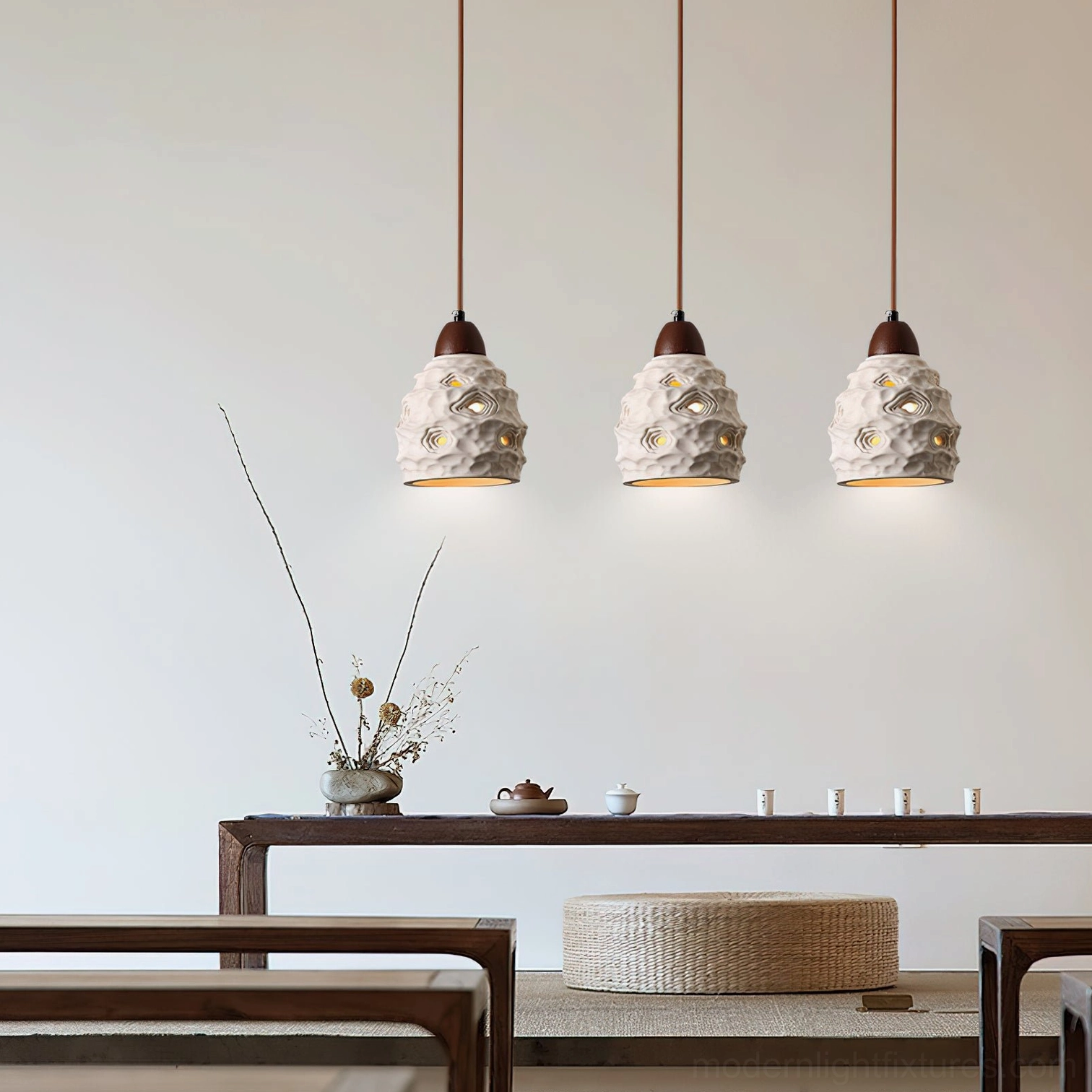 Triple ceramic pendant lights with organic texture in contemporary tea room with warm interior ambient glow