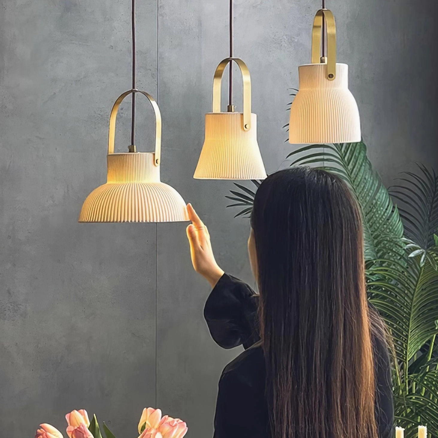 Set of three matching ceramic pendant lights installed in contemporary dining room with grey accent wall