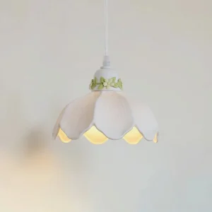 Ceramic pendant light hanging indoors casting warm ambient glow, hand-painted botanical design visible through translucent shade