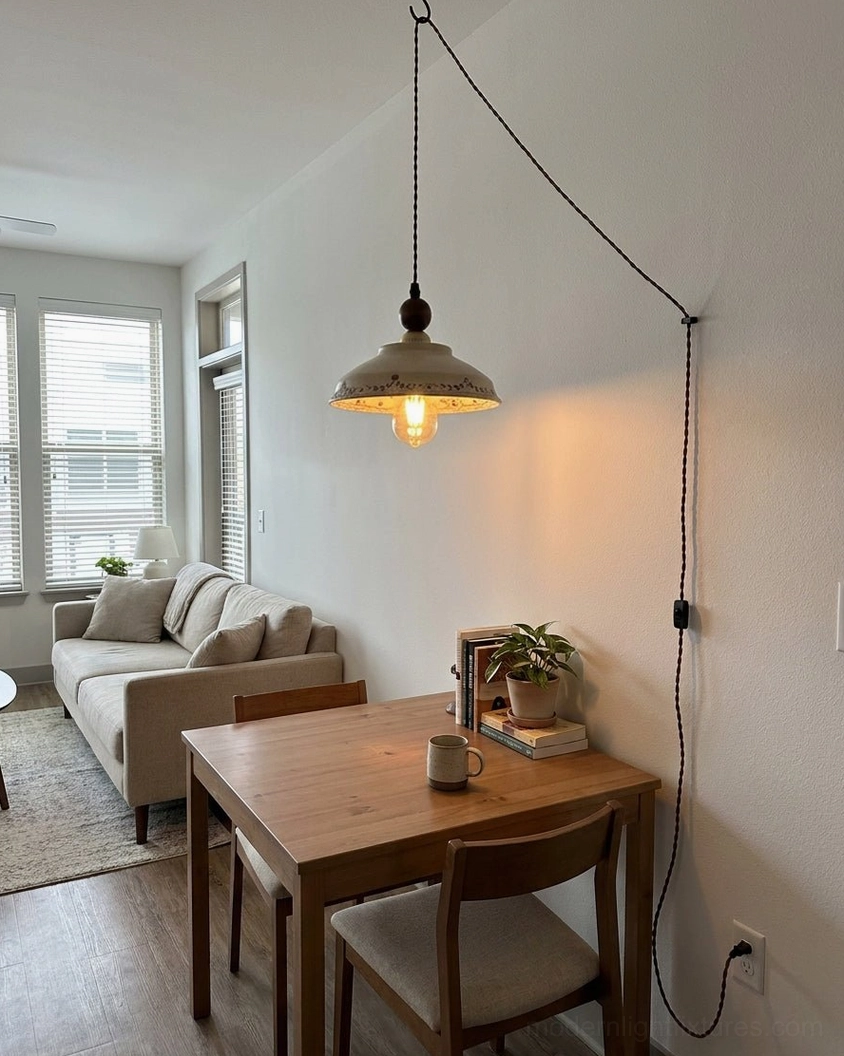 Plug-in pendant light hanging above dining table in open-plan living space, warm ambient light illuminating hand-painted ceramic shade and interior