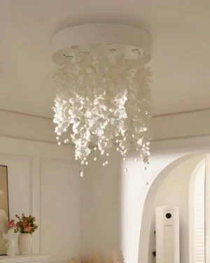 Luxury white petal chandelier installed in minimalist French cream interior with soft warm lighting, eye-level perspective
