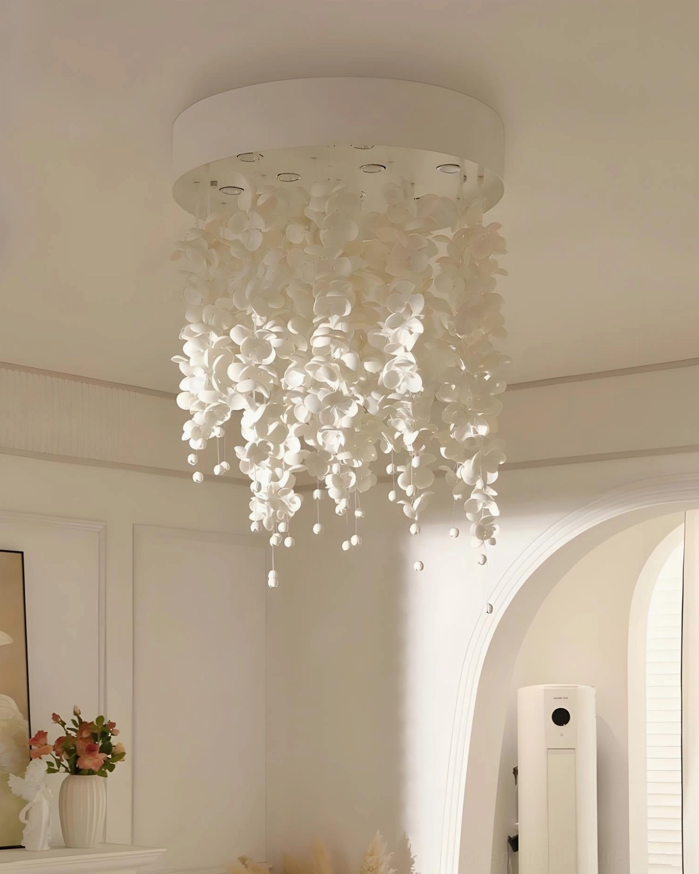 Luxury white petal chandelier installed in minimalist French cream interior with soft warm lighting, eye-level perspective