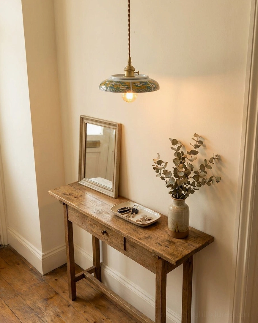 Ceramic saucer pendant light creating warm glow over vanity table with dried flowers and wooden furniture