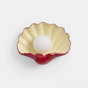 Scallop shell ceramic wall sconce with cream and burgundy two-tone finish, front view on white background, sculptural coastal lighting