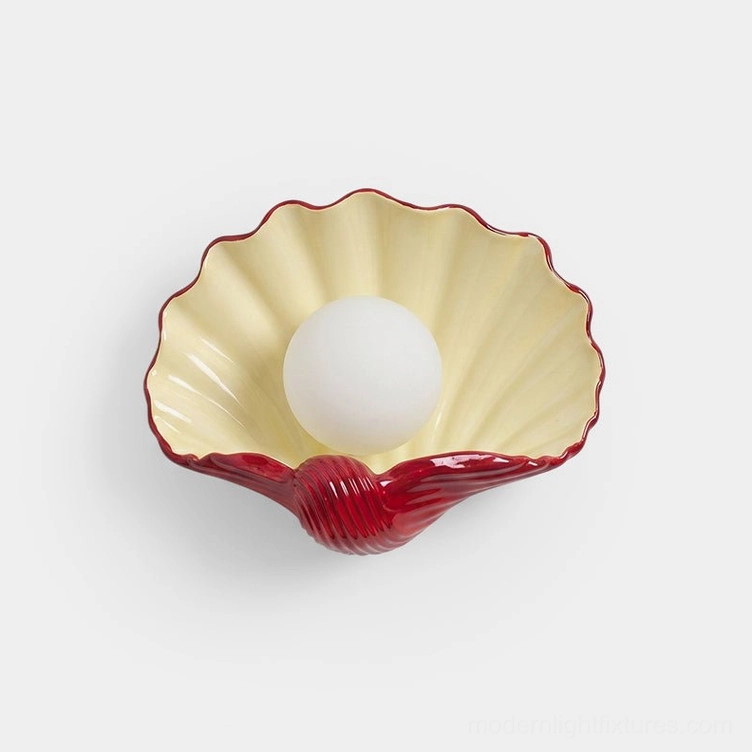 Scallop shell ceramic wall sconce with cream and burgundy two-tone finish, front view on white background, sculptural coastal lighting