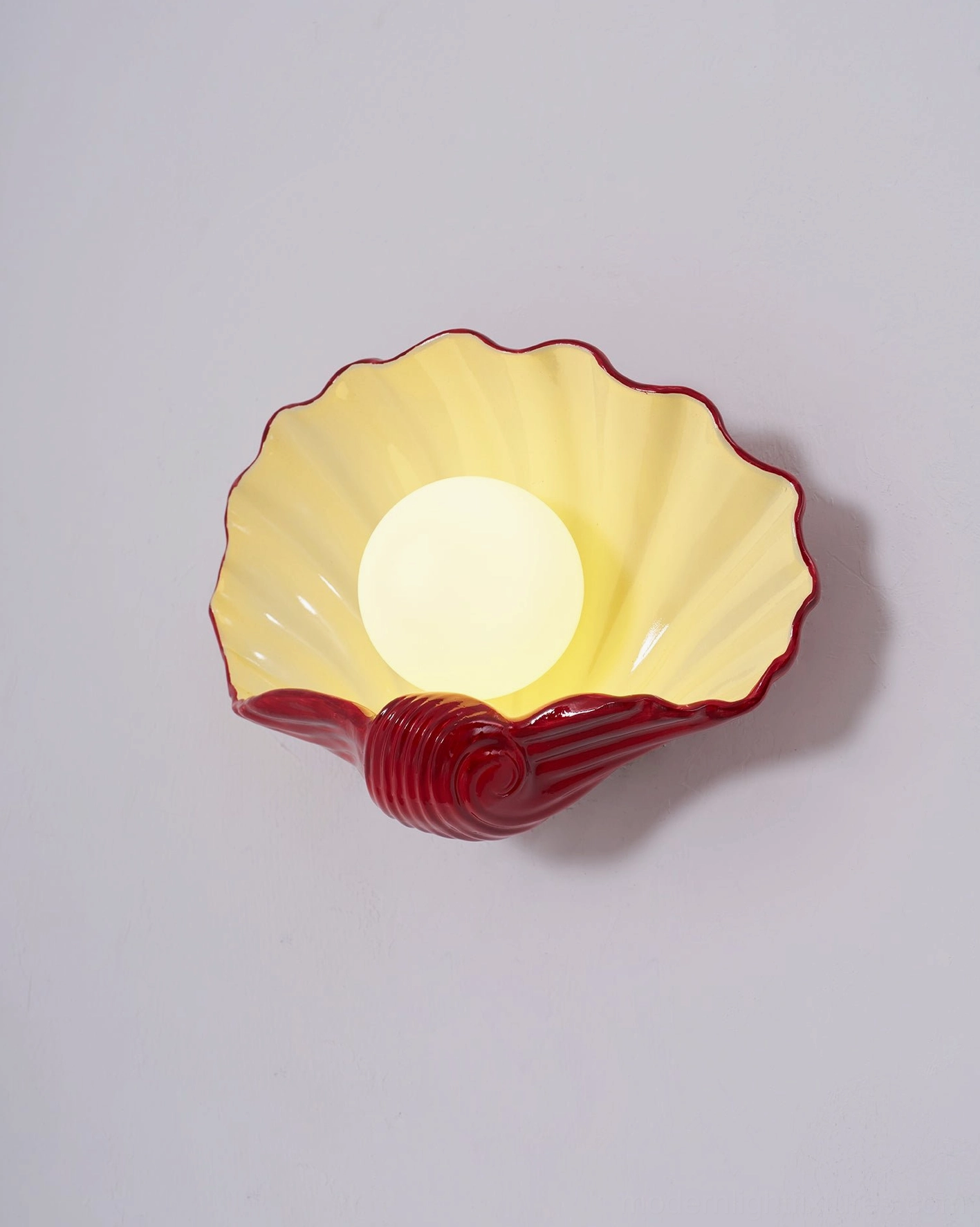 Ceramic scallop wall lamp in modern bedroom accent, soft glow lighting, contemporary coastal design fixture