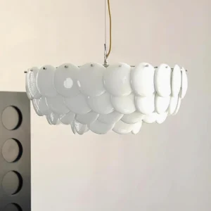 Close-up detail of white ceramic shell chandelier with gold suspension cord and layered oval shade elements