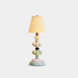 Handcrafted ceramic table lamp with blue and white striped base and pleated fabric shade featuring blue felt flower accent, front studio view