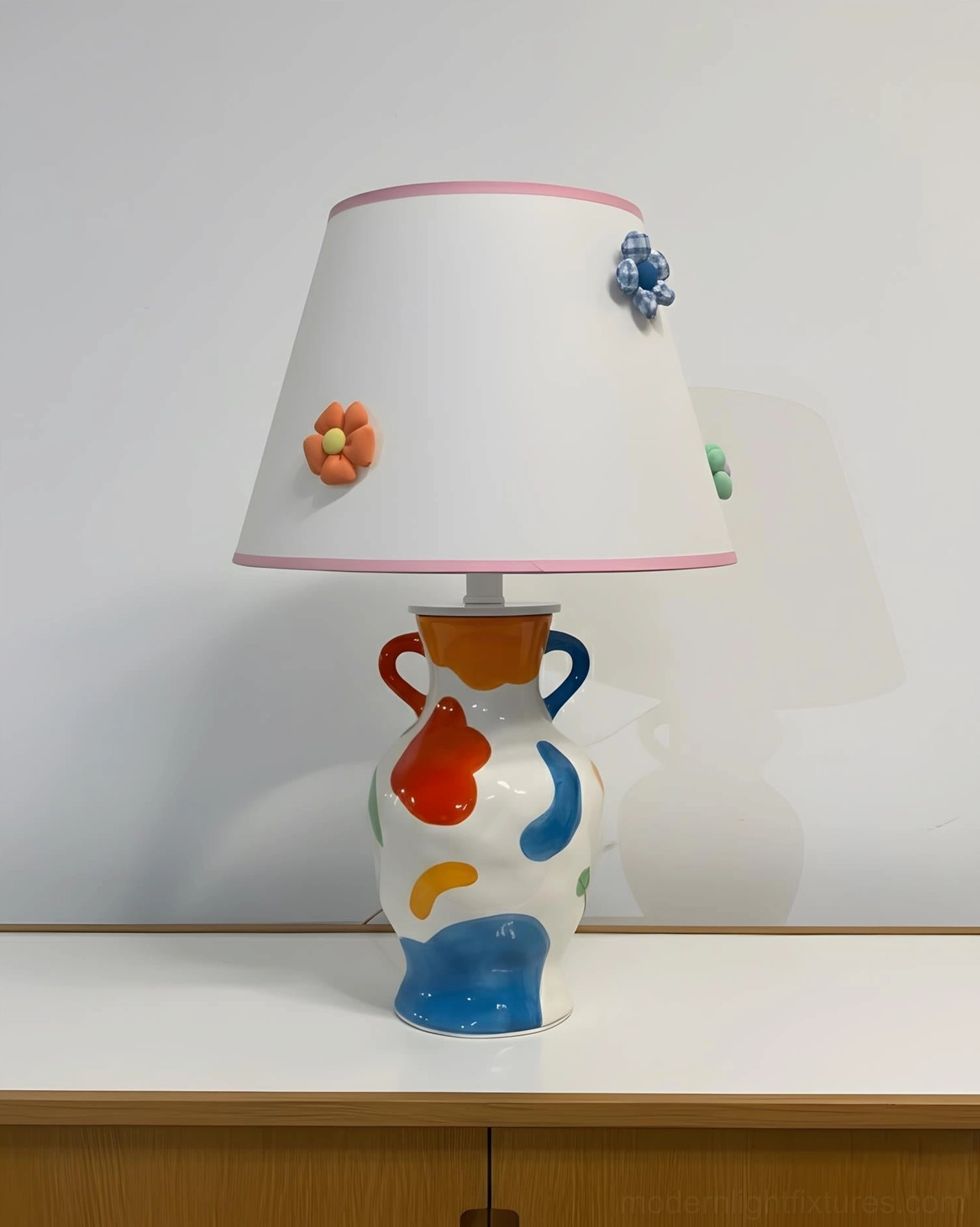 Hand-painted ceramic table lamp with soft pink trimmed white shade and multicolor painted ceramic base, ambient lighting view