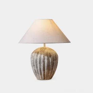 Modern ceramic textured table lamp with ribbed base and beige linen shade on white background