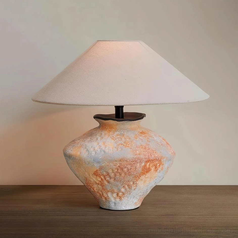 Ceramic table lamp low angle view on warm wooden tabletop distressed base cream shade
