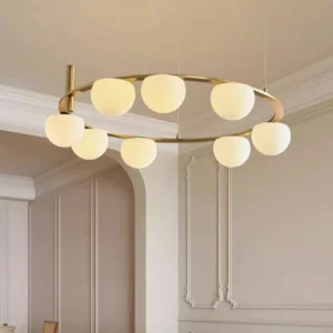 Modern brass ring chandelier with white frosted glass shades glowing in luxury French bedroom interior