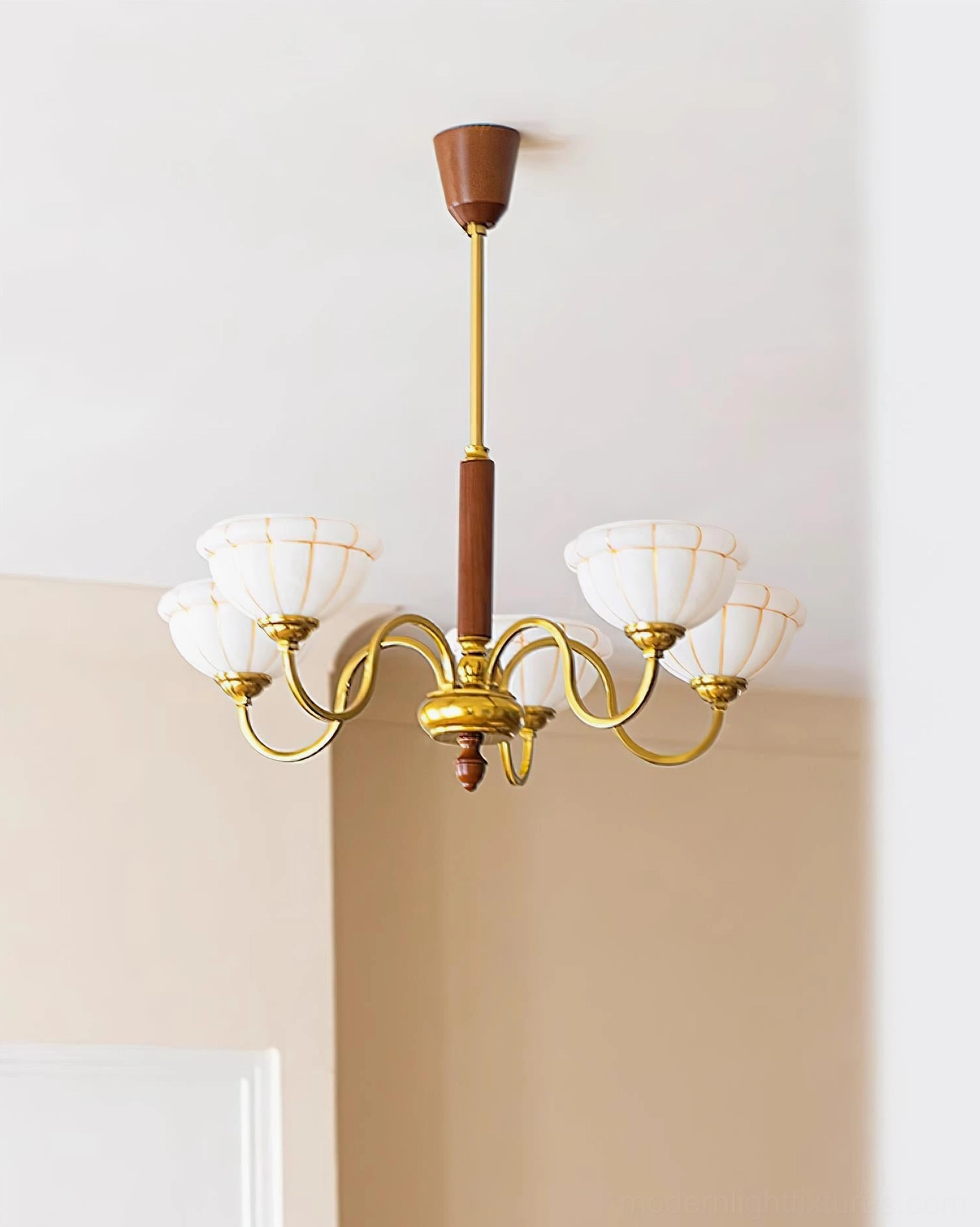 Charlie vintage chandelier in minimalist residential space showing six brass arms and frosted shades detail