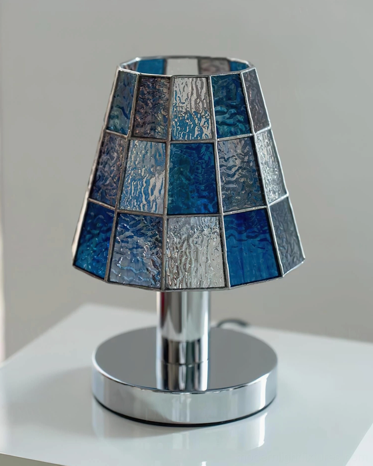 Close-up front view of blue checkered stained glass shade showing intricate geometric pattern detail on modern table lamp