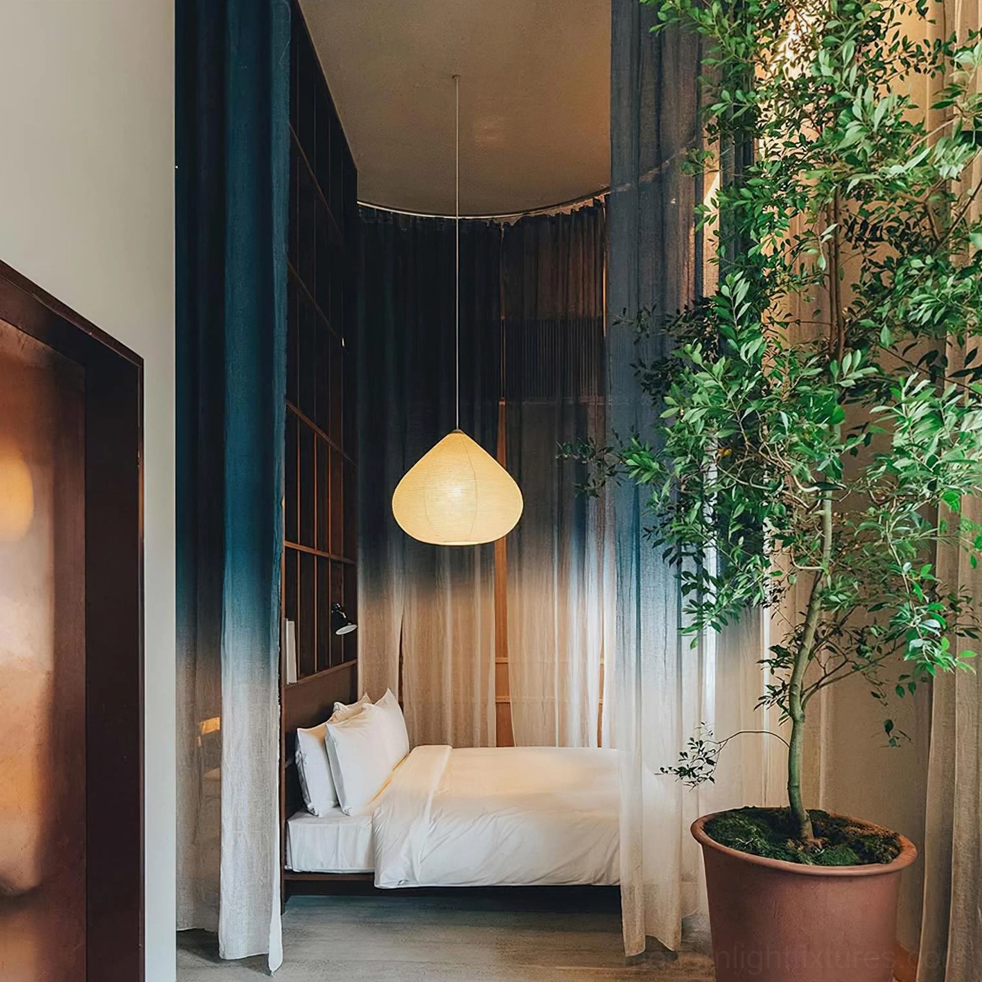 Teardrop shaped paper pendant lamp creating soft warm glow in luxury hotel bedroom