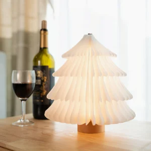 Christmas tree folding table lamp on wooden countertop with wine bottle and glass, warm ambient lighting