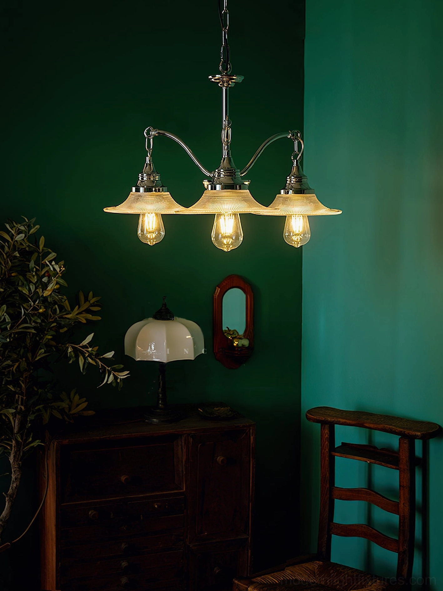 3-head modern chrome chandelier with flat clear glass shades in dark green transitional interior space