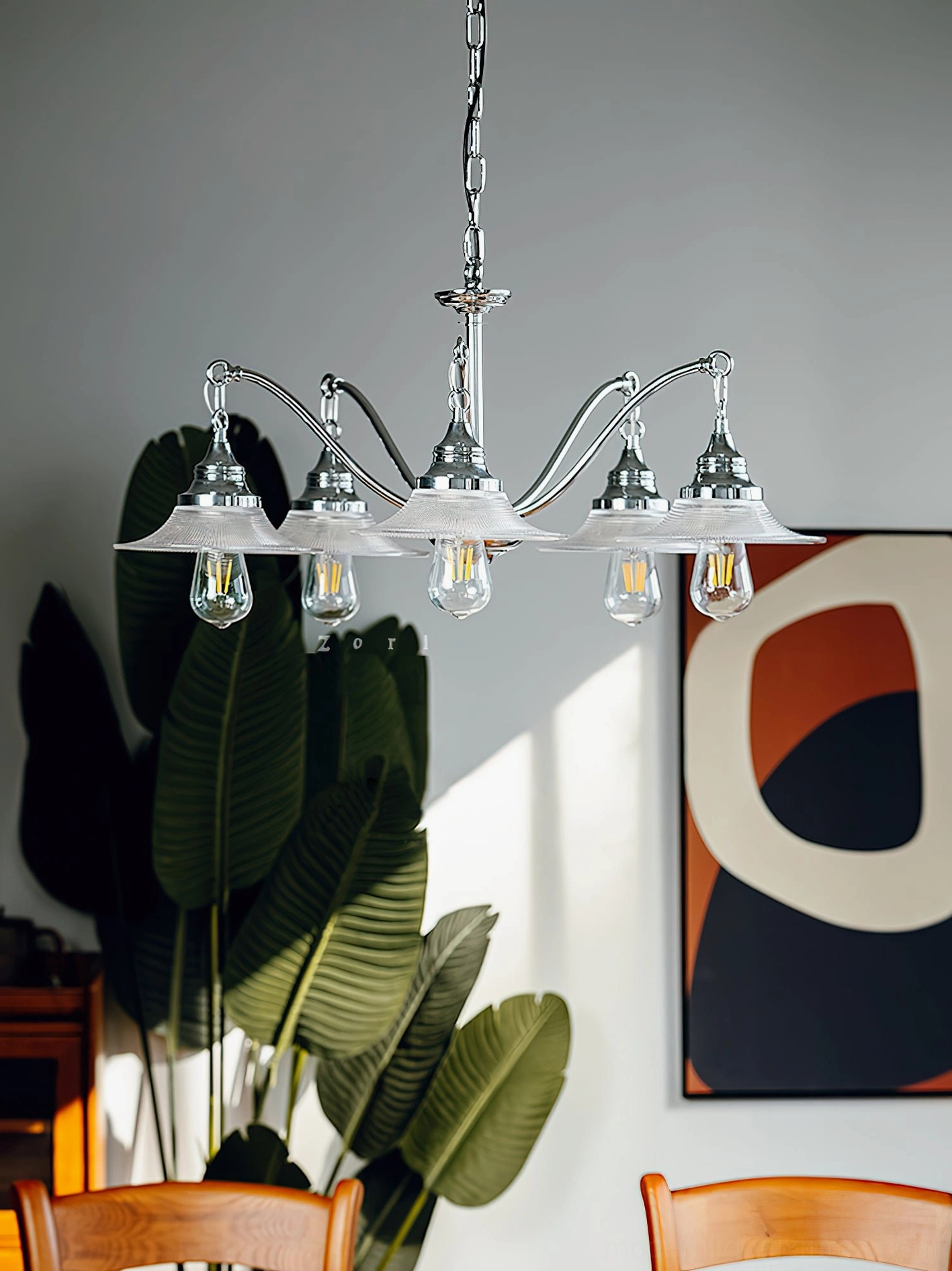 5-head modern chrome chandelier with ribbed glass shades in vintage-style dining space with green plants