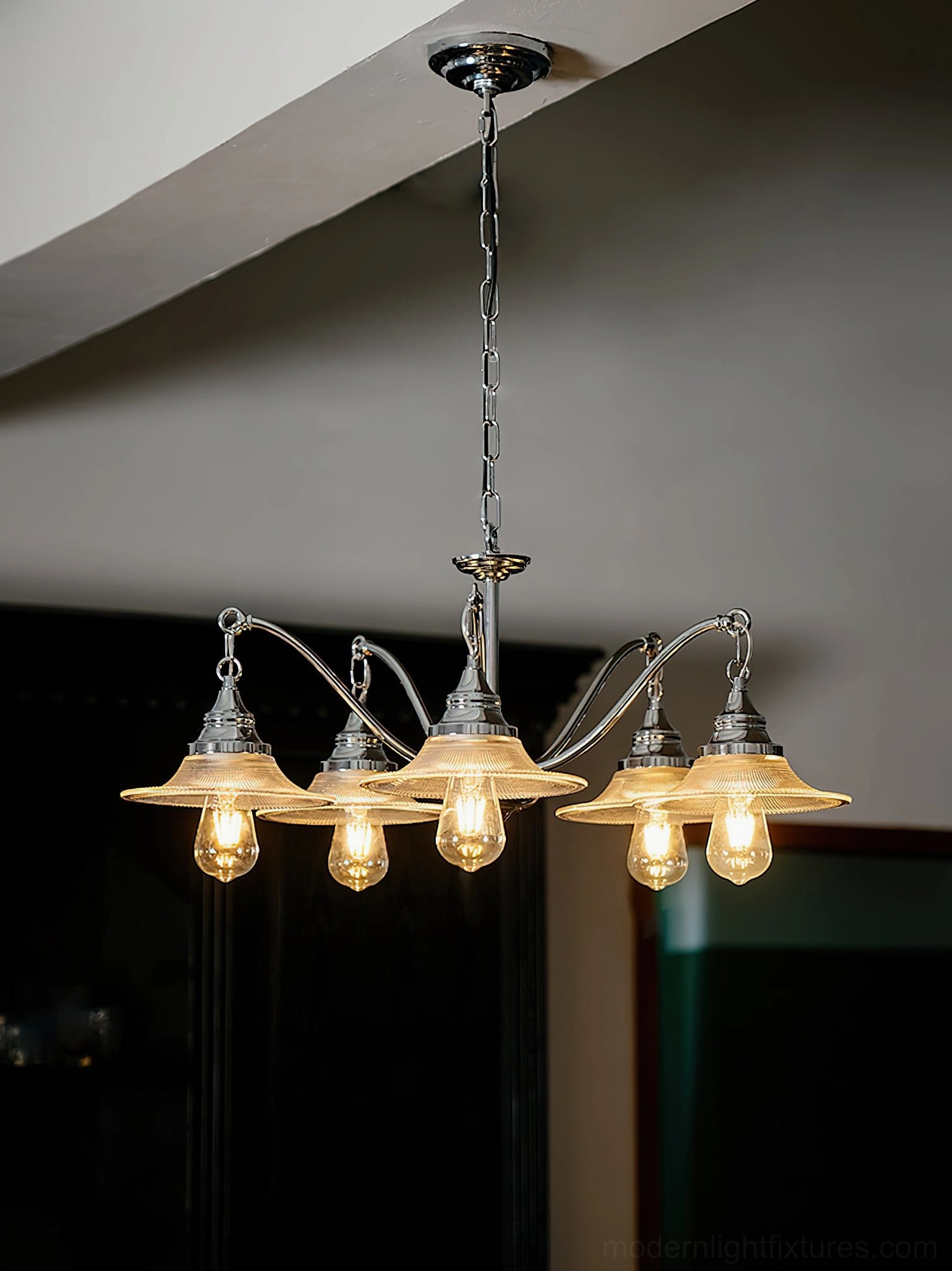 5-head chrome chandelier low angle view with fluted glass shades and warm glowing Edison bulbs