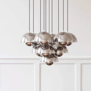 Contemporary chrome pendant chandelier close-up displaying polished metal hemispherical domes with clustered layered design against blank studio background