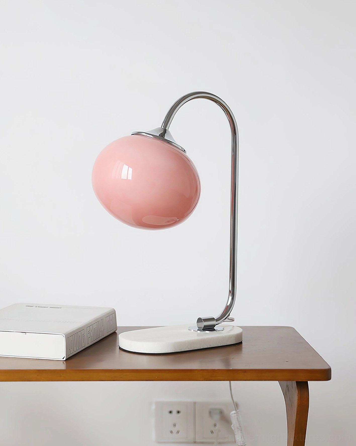 Chrome metal frame globe table lamp with pink glass shade and white marble base displaying elegant design