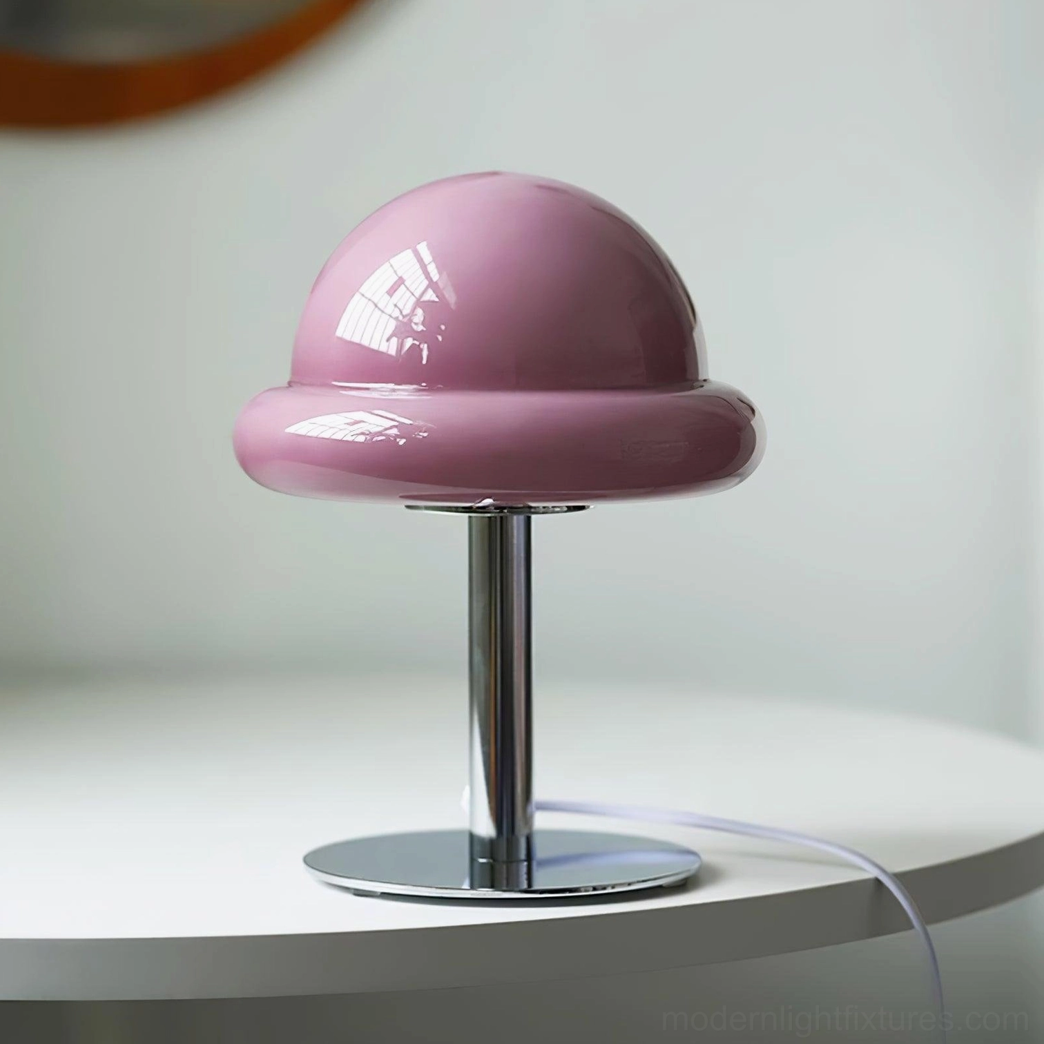 Modern mushroom table lamp in chrome metal finish creating minimalist industrial aesthetic on desk